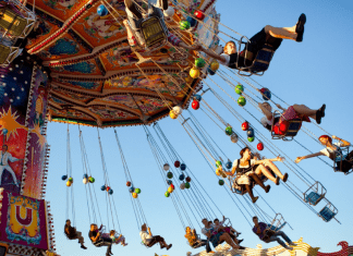 People on a large swing at a fair.