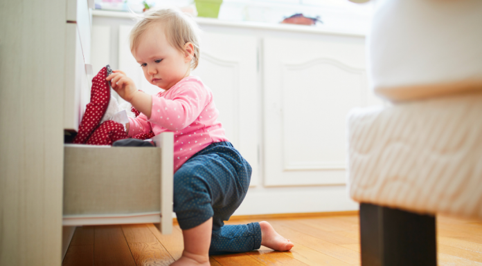 A baby getting into a drawer.