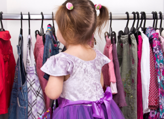 A little girl looking at clothing.