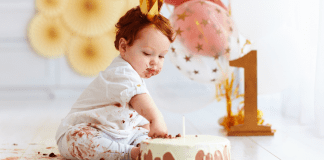 A baby with a first birthday cake.