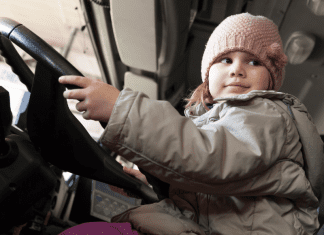 A toddler sitting in a truck.