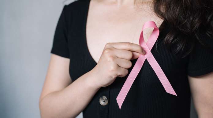 A woman holding a pink breast cancer symbol.