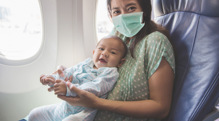 A mom holding a baby on an airplane.