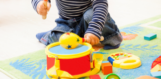 Baby playing with a toy drum.