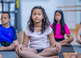 Kids taking a meditation class.