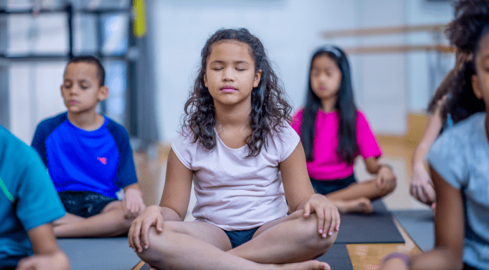 Kids taking a meditation class.