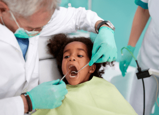 A kid sitting in the dentist chair.