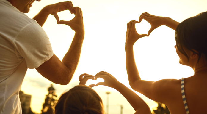 The Power of Laughter: Finding Joy Day to Day A family making hearts with their fingers.