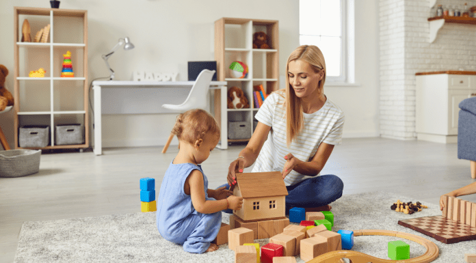 A babysitter playing blocks with a little boy.
