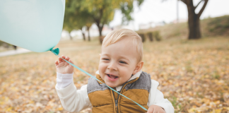 A toddler holding a balloon.