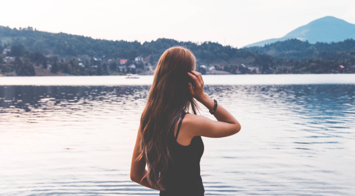 A woman looking at a lake.