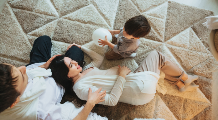 Time With #2 A family laying down that's expecting a second baby.