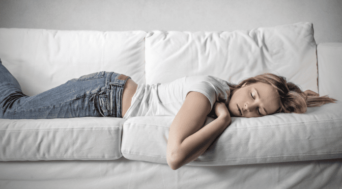 Teen girl sleeping on a couch.