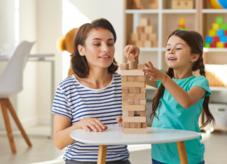 A caregiver playing with a girl.