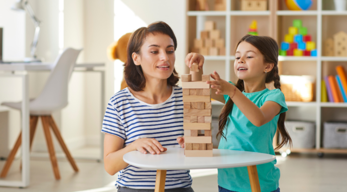 A caregiver playing with a girl.