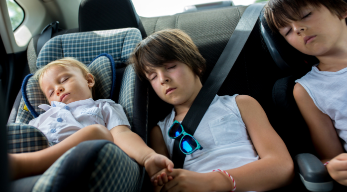 Children sleeping in a car during holiday travel.