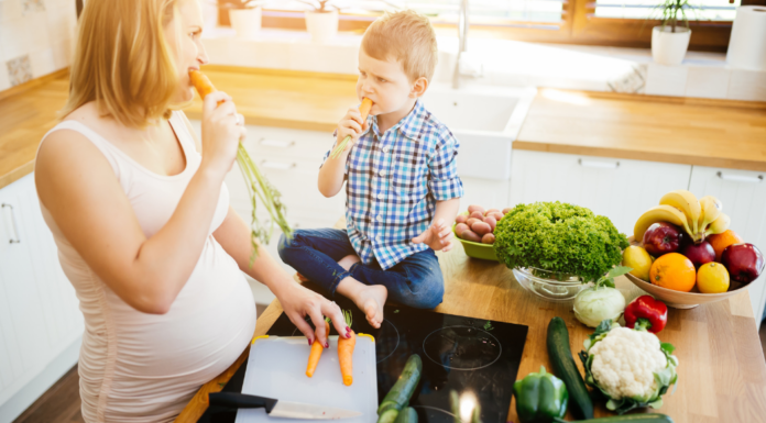A pregnant mom feeding her son.