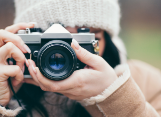 A woman holding a camera and taking a photo.
