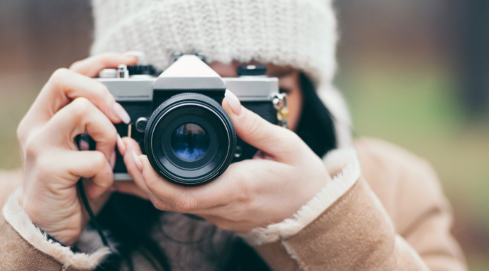 A woman holding a camera and taking a photo.