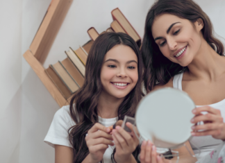A mother and a daughter putting on makeup.