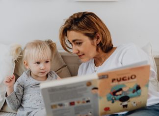 A mom reading a book to her toddler.
