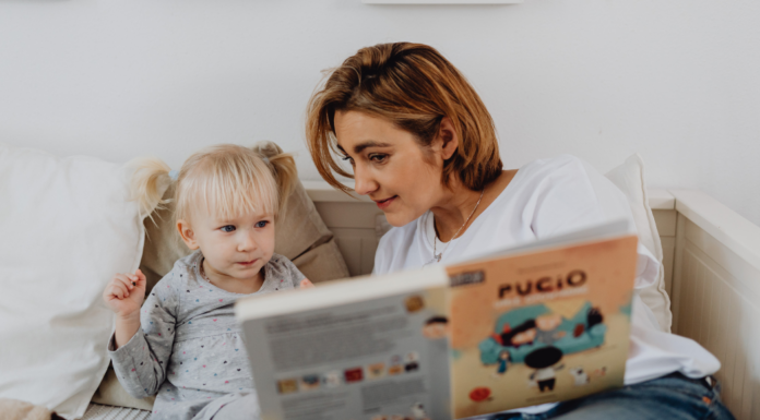 A mom reading a book to her toddler.