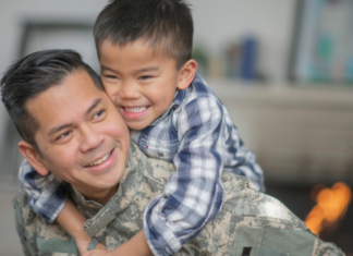 A dad holding his son on his back.
