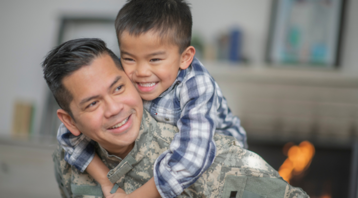 A dad holding his son on his back.
