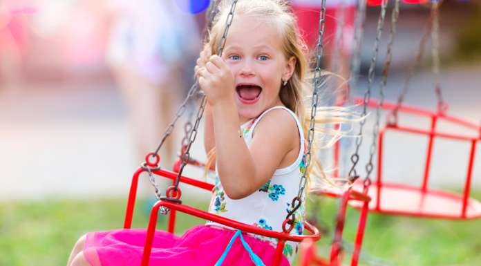 A girl on swing at a summer fair.