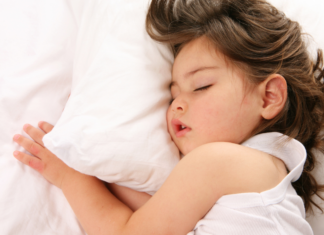 Helping Your Child Adjust to The End of Daylight Saving Time A girl sleeping.