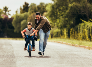 A father teaching his son to ride a bike.