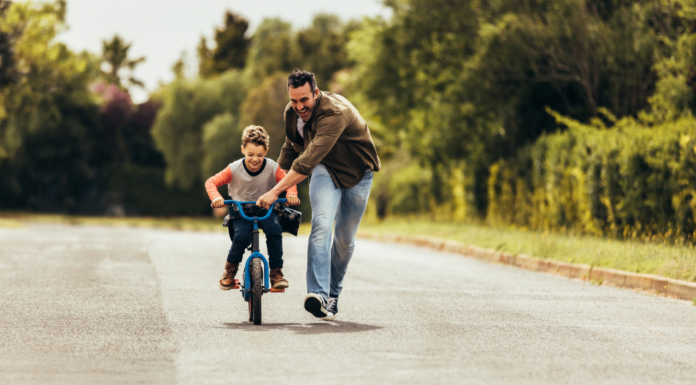A father teaching his son to ride a bike.