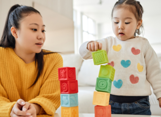stay-at-home mom building blocks with her daughter.