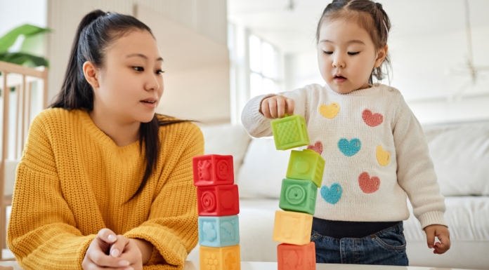 stay-at-home mom building blocks with her daughter.