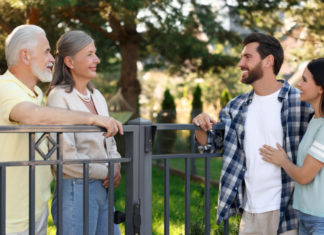 Neighbors speaking over a fence.