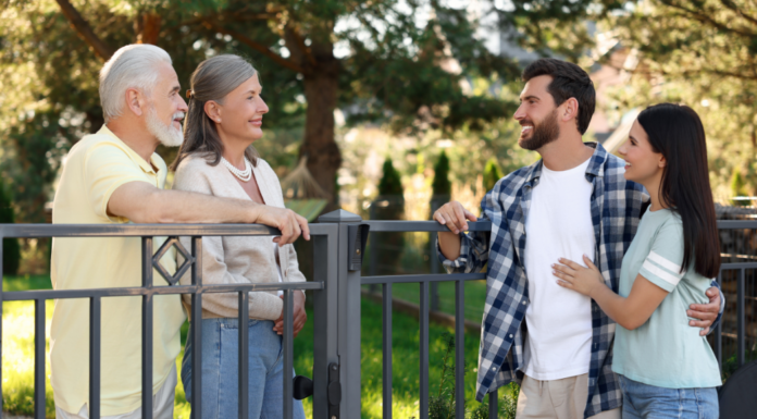 Neighbors speaking over a fence.