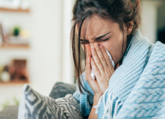 A sick mom blowing her nose.