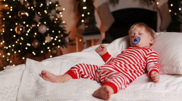 A toddler boy asleep in his Christmas pajamas.