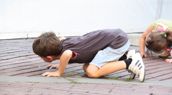A curious boy looking on the ground.