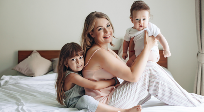A tired mom holding her kids.