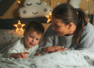 A mom and son laying in bed to avoid bedtime.