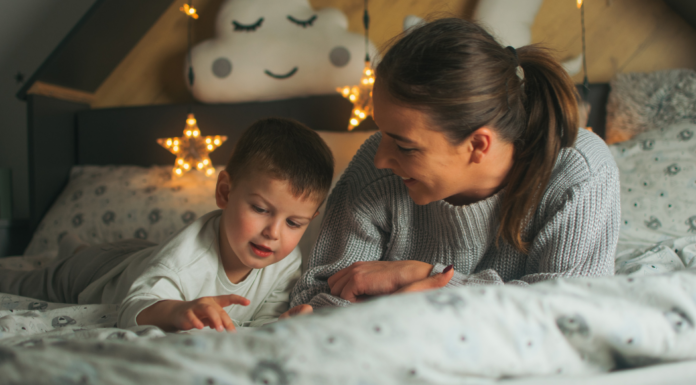 A mom and son laying in bed to avoid bedtime.