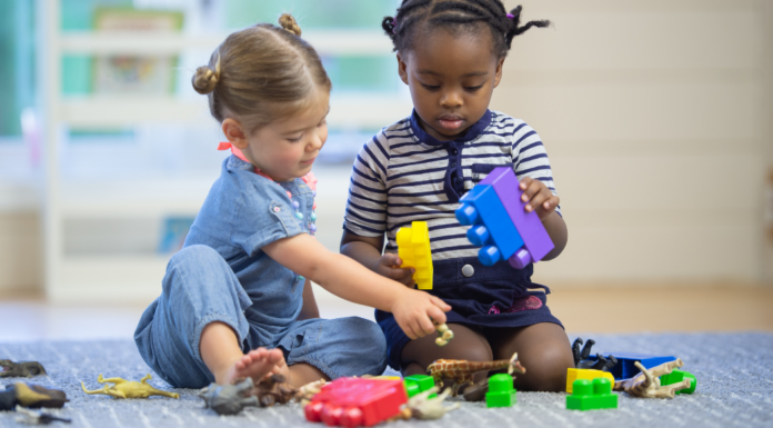 Two children playing together with blocks.