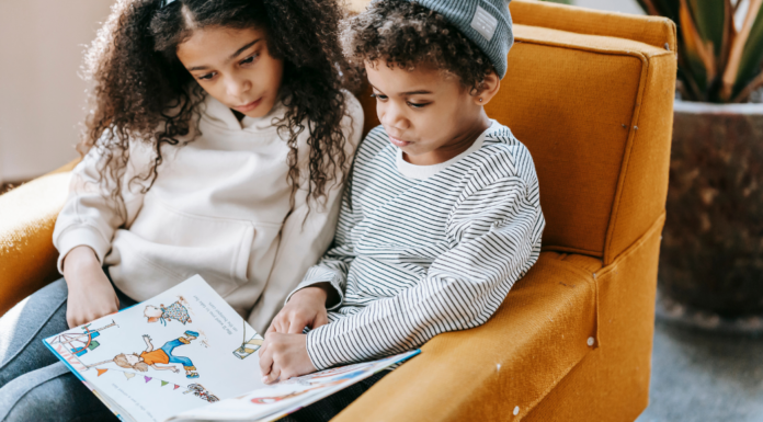 Kids reading a book together.