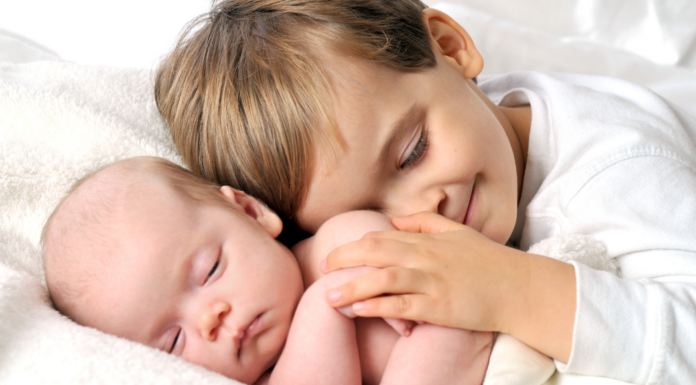 A big brother holding his new baby brother.