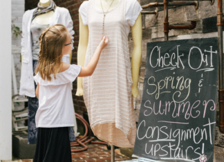 A girl looking at clothing at a spring consignment sale.