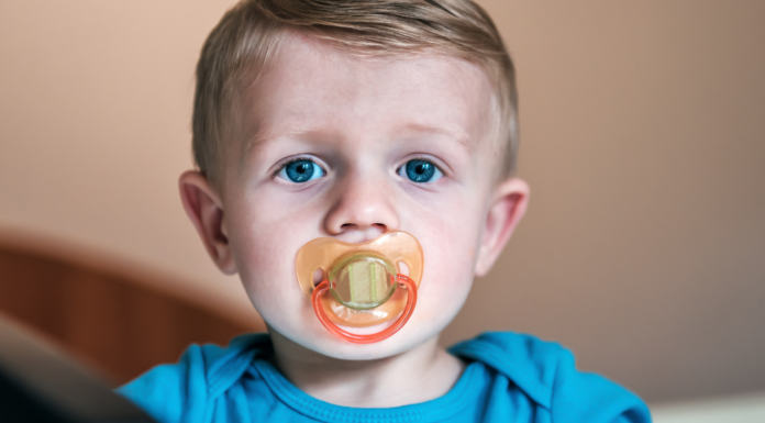 A toddler with a pacifier.