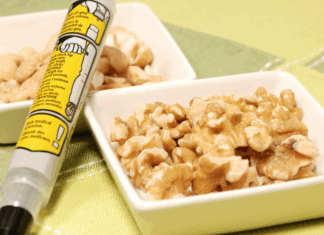 React with Respect: Food Allergy Action Month An epi pen next to a bowl of walnuts.