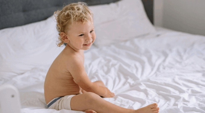 A toddler sleeping in a big boy bed.