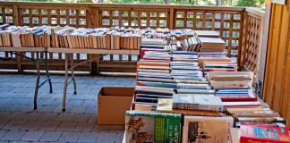 Books lined up on tables at a book sale.